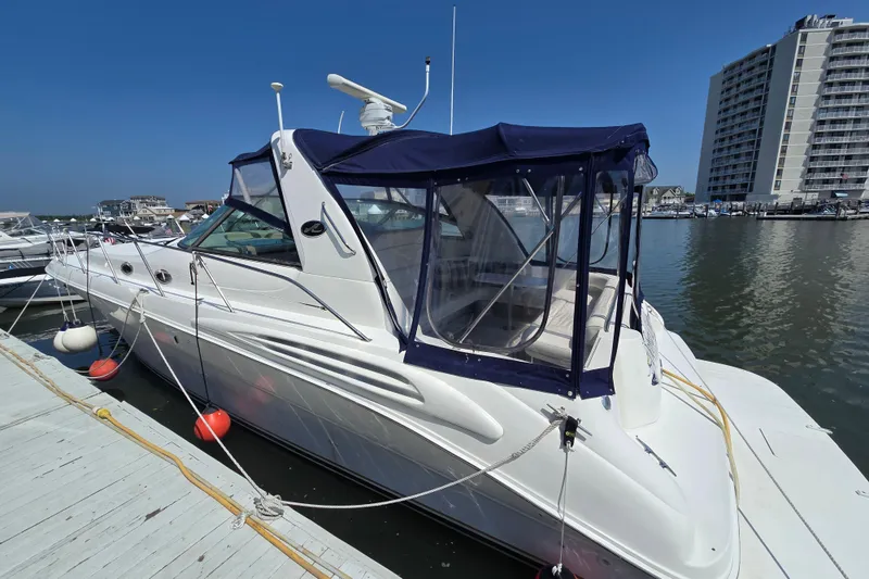 Slide: The Image of 1999 Sea Ray Sundancer 400 yacht docked at marina, featuring blue canopy and sleek design. - 4