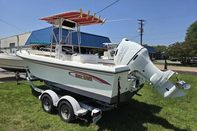 Slide: The Image of 2000 May-Craft 2000CC boat on trailer with Suzuki outboard motor, parked on grass. - 1