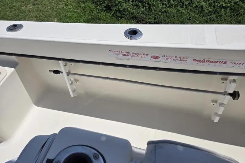 Slide: The Image of Interior view of a 2000 May-Craft 2000CC boat, featuring rod holders and storage. - 16