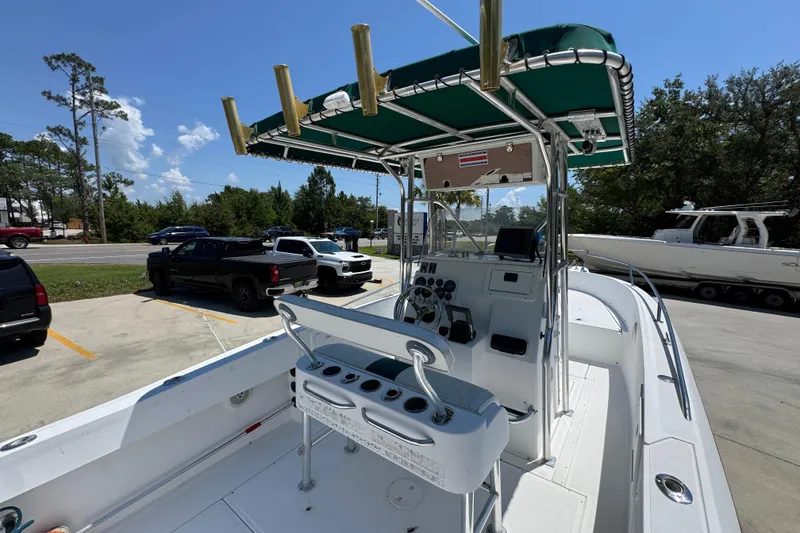 Slide: The Image of 2000 Stamas 250 Tarpon boat with green canopy, parked in a lot under a clear blue sky. - 42
