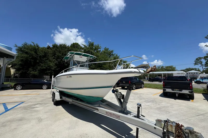 Slide: The Image of 2000 Stamas 250 Tarpon boat on trailer in parking lot under clear blue sky. - 7