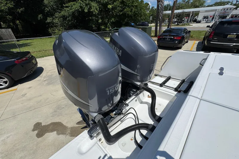Slide: The Image of Twin Yamaha 150 engines on a 2000 Stamas 250 Tarpon boat in a parking lot. - 49
