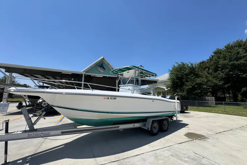 Slide: The Image of 2000 Stamas 250 Tarpon boat on trailer, parked outdoors under clear blue sky. - 3