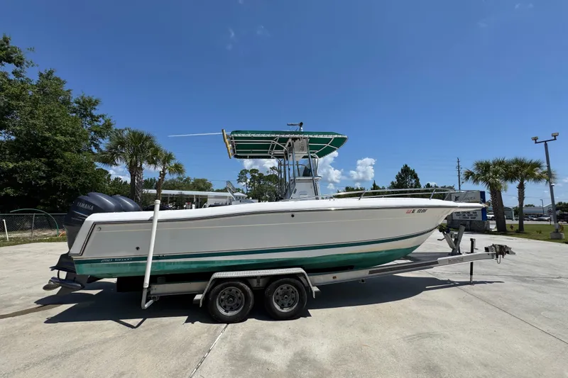 Slide: The Image of 2000 Stamas 250 Tarpon boat on trailer, parked outdoors under clear blue sky. - 10