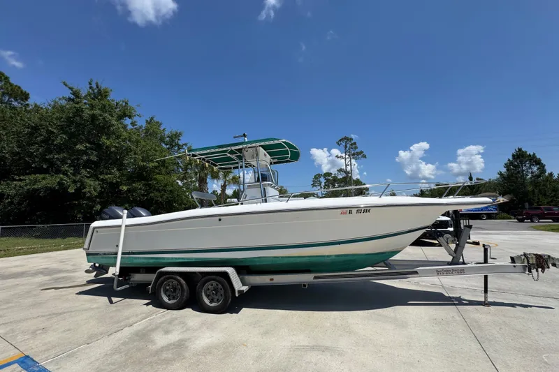 Slide: The Image of 2000 Stamas 250 Tarpon boat on trailer, parked outdoors under clear blue sky. - 9