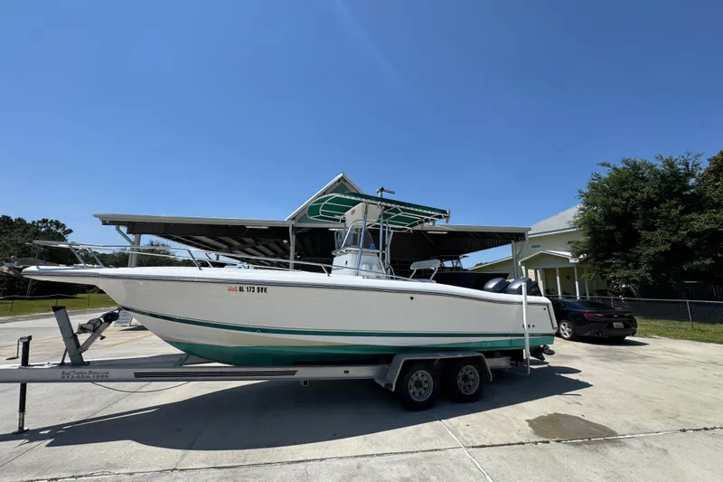 Slide: The Image of 2000 Stamas 250 Tarpon boat on trailer, parked outdoors under clear blue sky. - 2