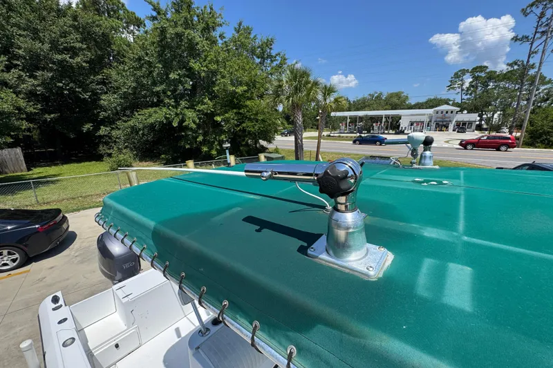 Slide: The Image of 2000 Stamas 250 Tarpon boat with green canopy and mounted equipment, parked outdoors. - 27