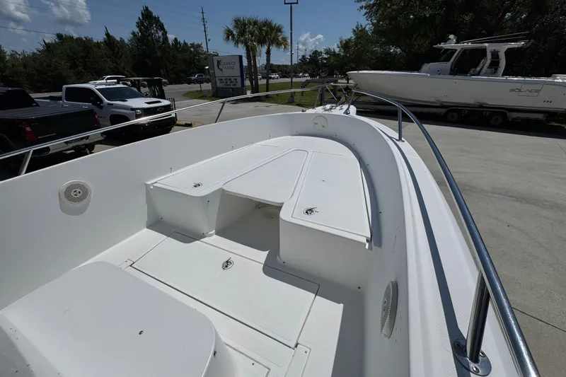 Slide: The Image of 2000 Stamas 250 Tarpon boat deck with seating, parked outdoors under clear sky. - 18