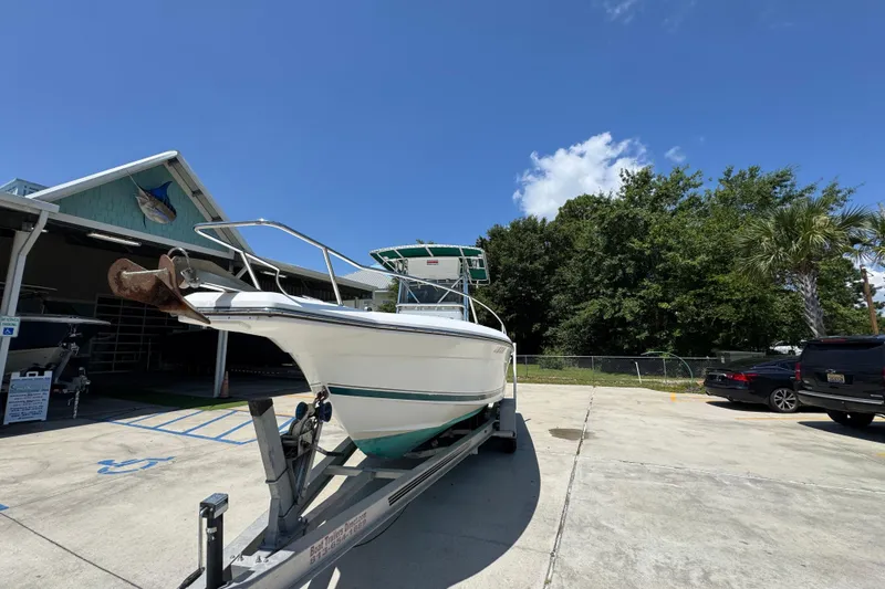 Slide: The Image of 2000 Stamas 250 Tarpon boat on trailer, parked outdoors under clear blue sky. - 5