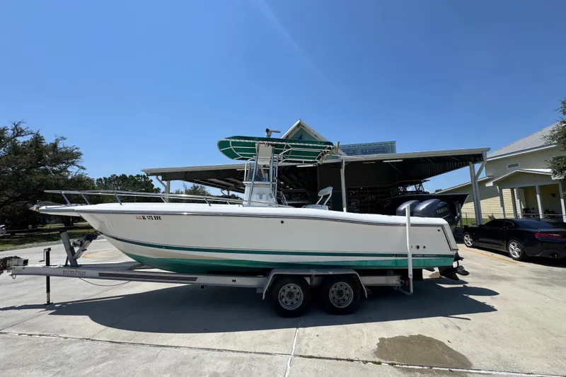 The Image of 2000 Stamas 250 Tarpon boat on trailer, parked outdoors under clear blue sky. - 1