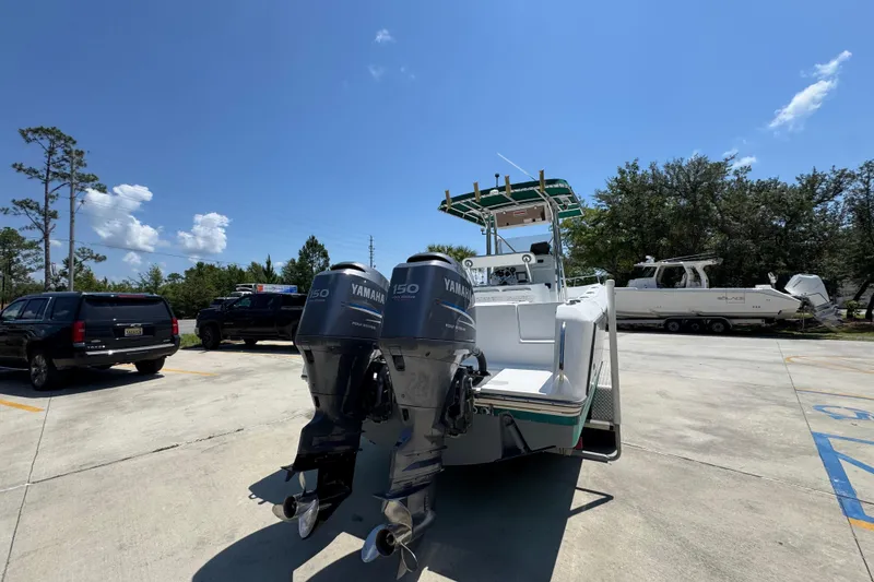 Slide: The Image of 2000 Stamas 250 Tarpon boat with dual Yamaha 150 engines in a parking lot. - 13