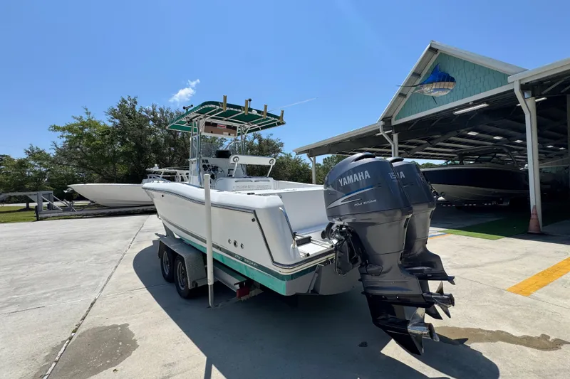 Slide: The Image of 2000 Stamas 250 Tarpon boat with Yamaha engines on a trailer, parked outdoors. - 16