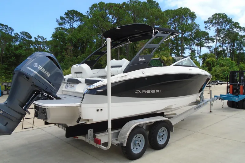Slide: The Image of 2024 Regal LX4 boat on trailer with Yamaha outboard motor, parked outdoors. - 3