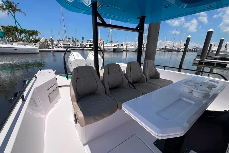 Slide: The Image of 2023 Axopar Brabus 37 Sun-Top boat interior with seating and table at marina. - 52