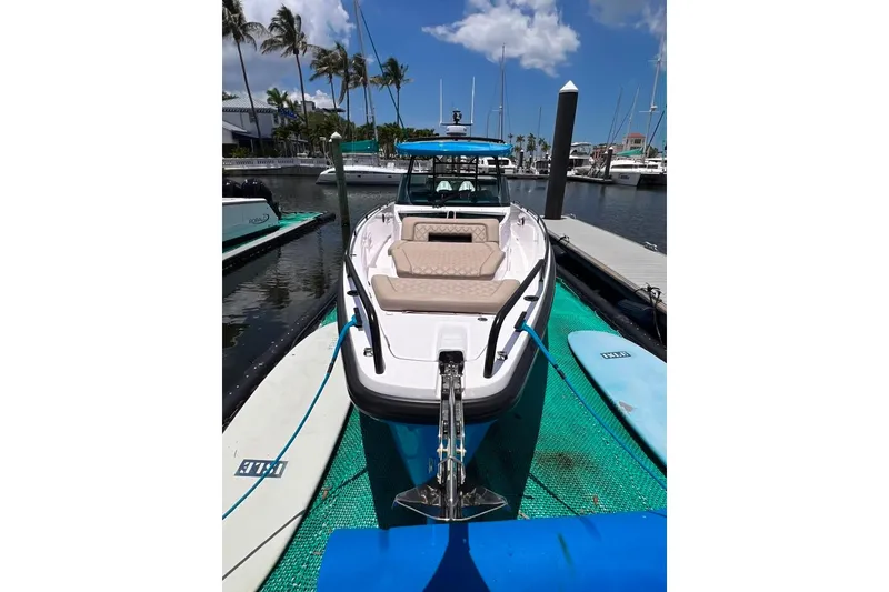 Slide: The Image of 2023 Axopar Brabus 37 Sun-Top boat docked at marina with paddleboards nearby. - 7