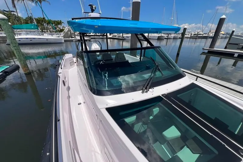 Slide: The Image of 2023 Axopar Brabus 37 Sun-Top boat docked in a marina under clear skies. - 60