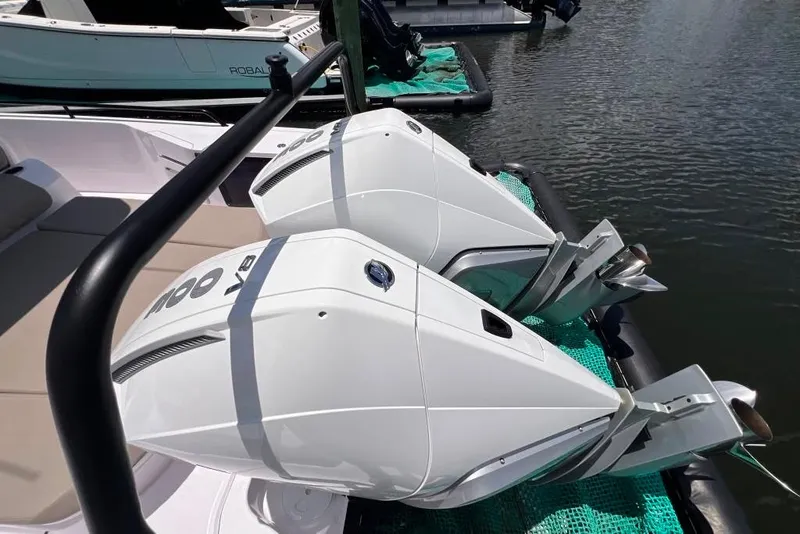 Slide: The Image of Twin outboard engines on a 2023 Axopar Brabus 37 Sun-Top boat docked by the water. - 28