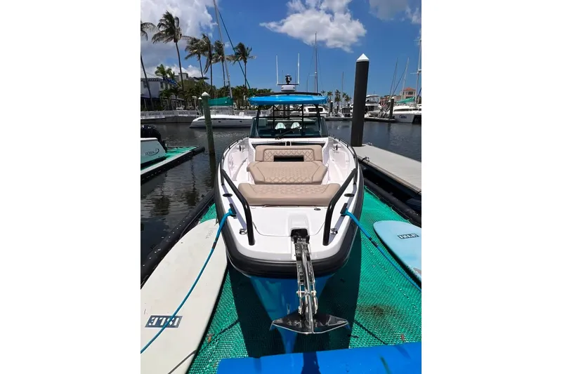 Slide: The Image of 2023 Axopar Brabus 37 Sun-Top boat docked at marina under clear blue sky. - 4
