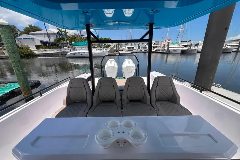 Slide: The Image of 2023 Axopar Brabus 37 Sun-Top boat interior with seating and table at marina. - 53