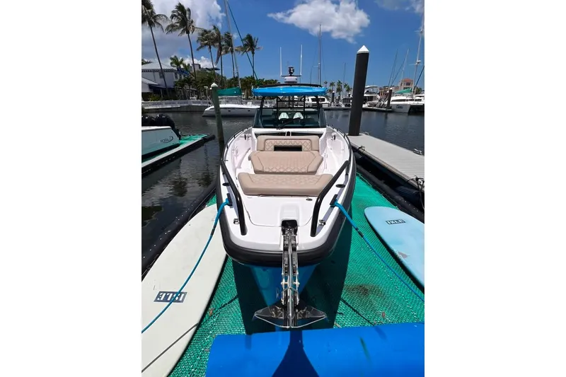 Slide: The Image of 2023 Axopar Brabus 37 Sun-Top boat docked at marina with paddleboards nearby. - 6