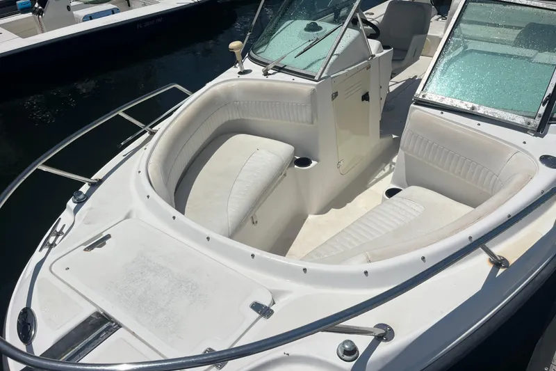 Slide: The Image of 2003 Boston Whaler 210 Ventura boat with white seating and windshield, docked in sunlight. - 10