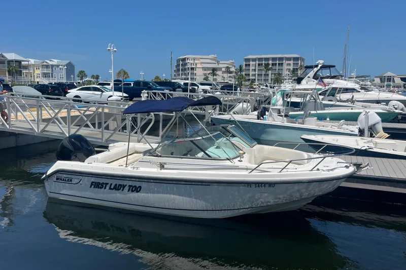 Slide: The Image of 2003 Boston Whaler 210 Ventura boat docked at marina with blue canopy. - 4