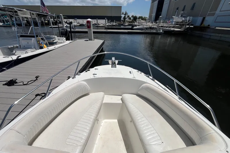 Slide: The Image of 2003 Boston Whaler 210 Ventura boat docked at marina, featuring spacious seating area. - 11