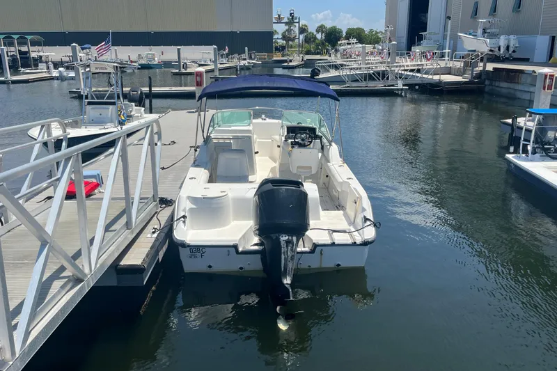 Slide: The Image of 2003 Boston Whaler 210 Ventura docked at marina, featuring outboard motor and canopy. - 7