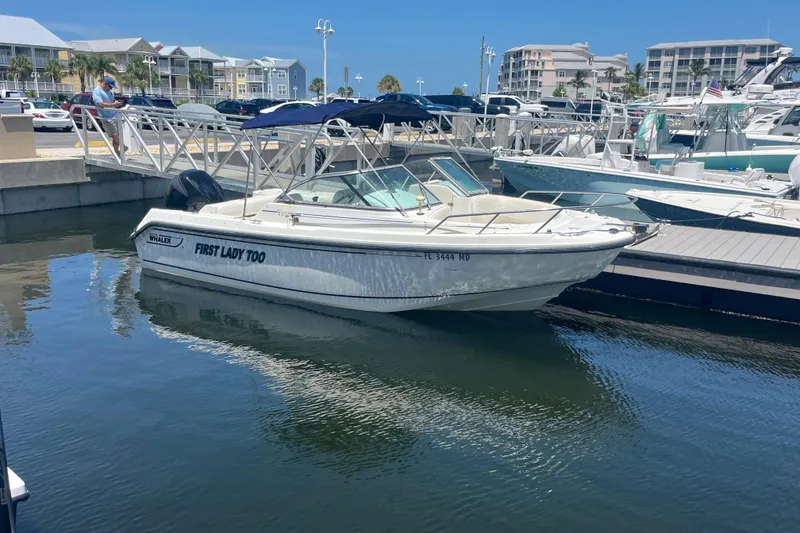 Slide: The Image of 2003 Boston Whaler 210 Ventura boat docked at marina, clear blue sky background. - 5