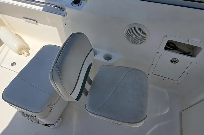 Slide: The Image of Two cushioned seats on a 2004 Aquasport 215 Osprey Sport boat interior. - 20