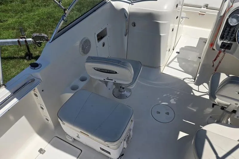 Slide: The Image of 2004 Aquasport 215 Osprey Sport boat interior with seating and control panel. - 14