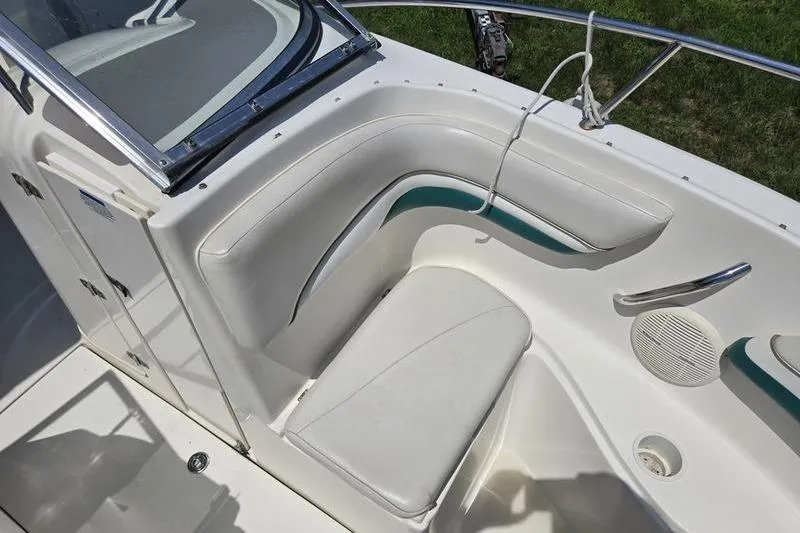 Slide: The Image of 2004 Aquasport 215 Osprey Sport boat interior with white seating and green accents. - 2