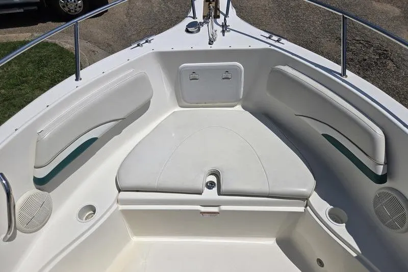 Slide: The Image of 2004 Aquasport 215 Osprey Sport boat interior with cushioned seating and storage compartments. - 7