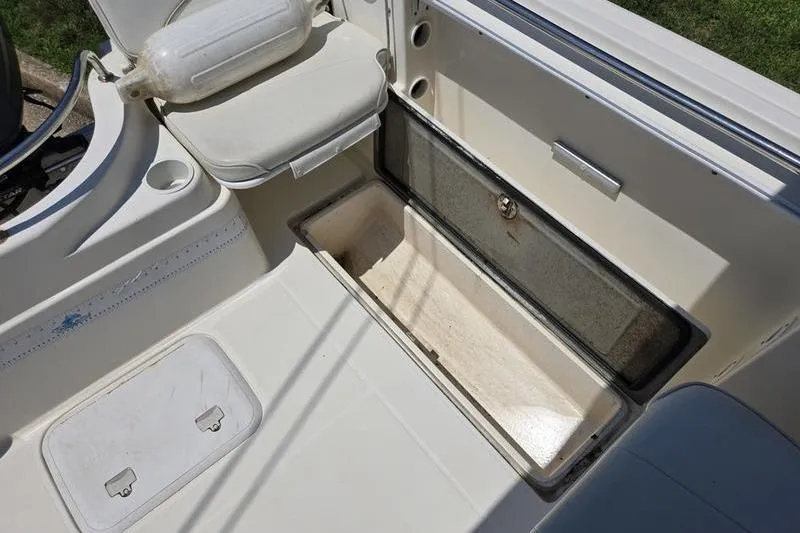 Slide: The Image of 2004 Aquasport 215 Osprey Sport boat interior with open storage compartment. - 5