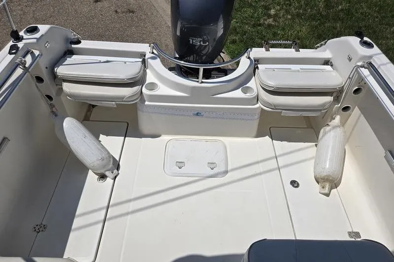 Slide: The Image of 2004 Aquasport 215 Osprey Sport boat interior with motor and seating. - 12