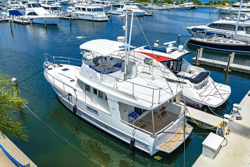 Slide: The Image of 2006 Beneteau Swift Trawler 42 docked at a marina, surrounded by other boats. - 17