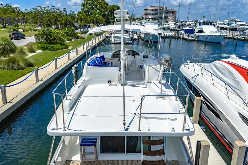 Slide: The Image of 2006 Beneteau Swift Trawler 42 docked at marina, showcasing spacious deck and elegant design. - 15