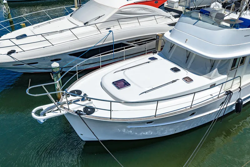Slide: The Image of 2006 Beneteau Swift Trawler 42 docked alongside another boat in a marina. - 19