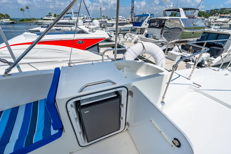 Slide: The Image of 2006 Beneteau Swift Trawler 42 deck with seating and mini fridge, docked at marina. - 60