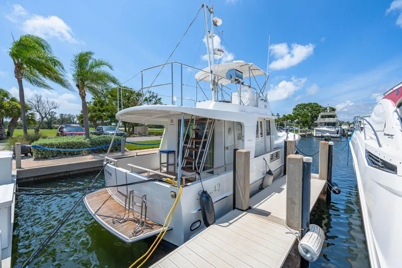 Slide: The Image of 2006 Beneteau Swift Trawler 42 docked at marina under clear blue sky. - 31