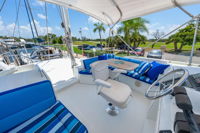 Slide: The Image of 2006 Beneteau Swift Trawler 42 flybridge with blue seating, steering wheel, and outdoor table. - 57
