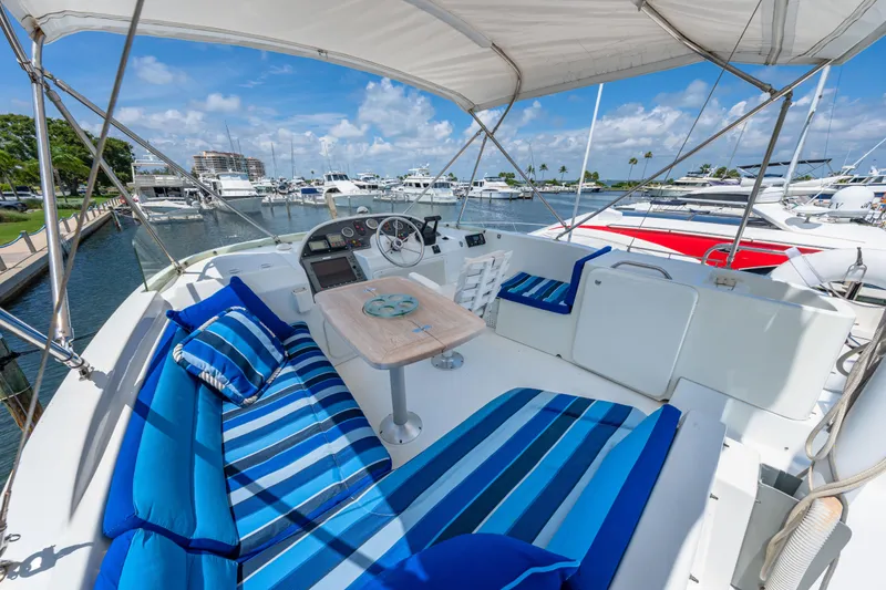 Slide: The Image of 2006 Beneteau Swift Trawler 42 with striped seating, docked at a marina under clear skies. - 55