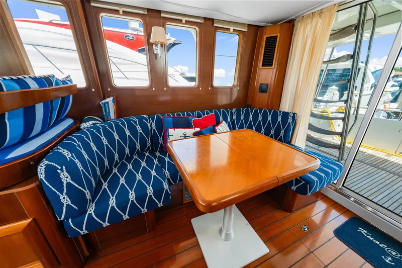 Slide: The Image of Interior of 2006 Beneteau Swift Trawler 42 with nautical-themed seating and wooden table. - 62