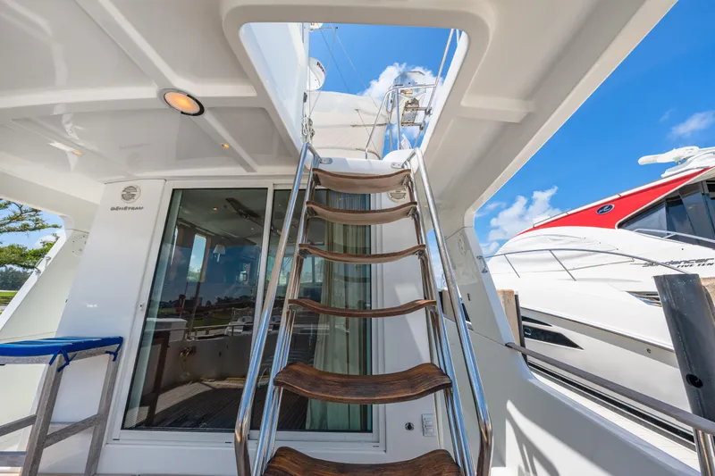 Slide: The Image of Staircase on 2006 Beneteau Swift Trawler 42 yacht, leading to upper deck under clear blue sky. - 47