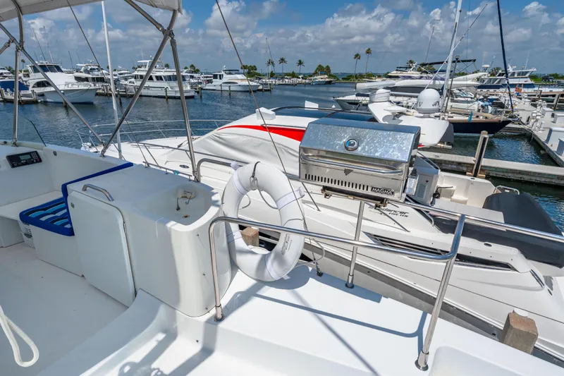 Slide: The Image of 2006 Beneteau Swift Trawler 42 docked, featuring a grill and life preserver on deck. - 53