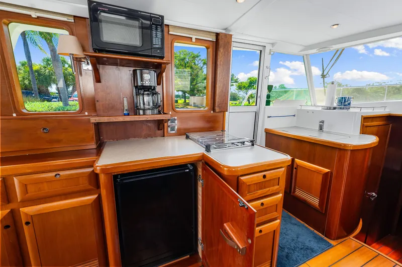 Slide: The Image of 2006 Beneteau Swift Trawler 42 kitchen with wood cabinetry, microwave, and outdoor view. - 65