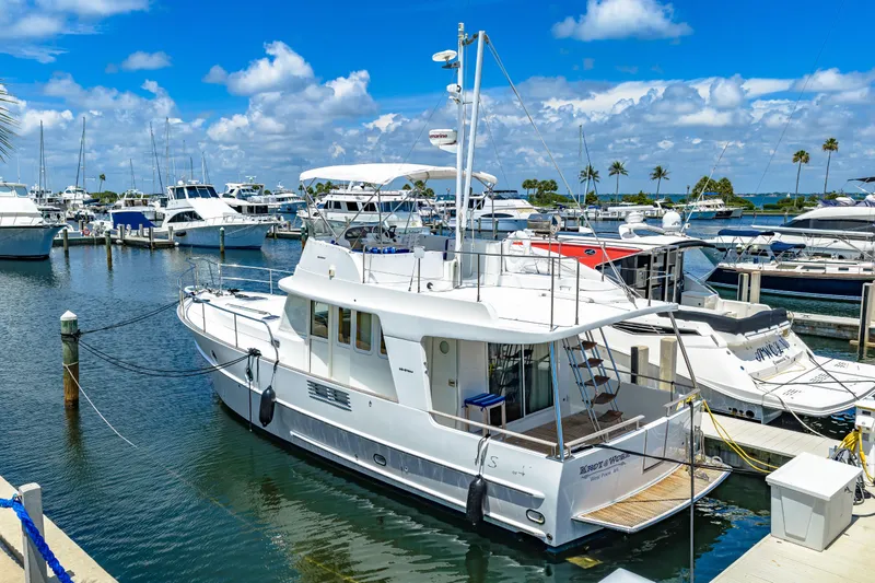 Slide: The Image of 2006 Beneteau Swift Trawler 42 docked at a marina under a clear blue sky. - 18
