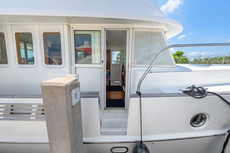 Slide: The Image of 2006 Beneteau Swift Trawler 42 docked, showcasing side entrance and sleek design. - 37