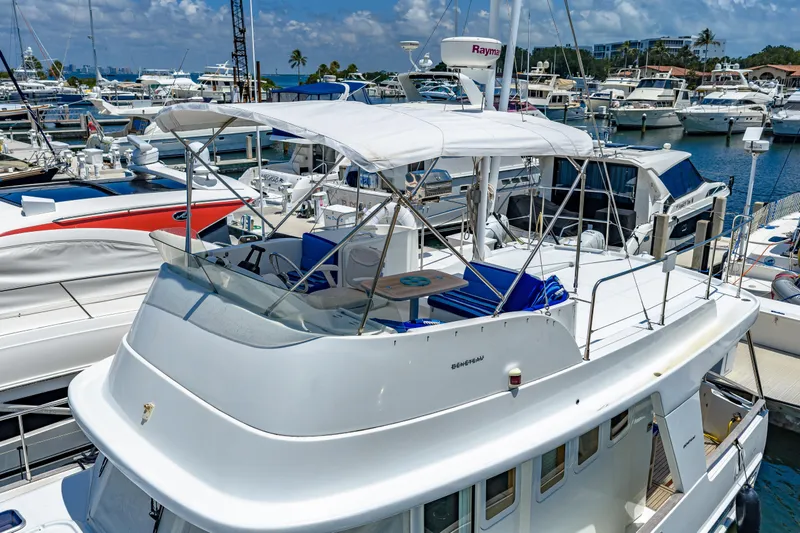 Slide: The Image of 2006 Beneteau Swift Trawler 42 docked in a marina, surrounded by other boats. - 21
