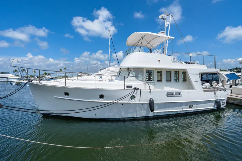 Slide: The Image of 2006 Beneteau Swift Trawler 42 docked in a marina under a clear blue sky. - 26